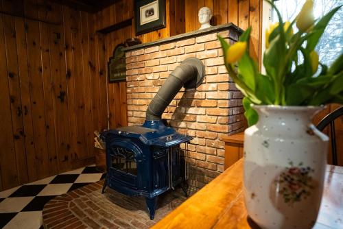 a blue stove sitting next to a brick wall at Twin Oaks Near Lake Wallenpaupack Historic Home in Hawley