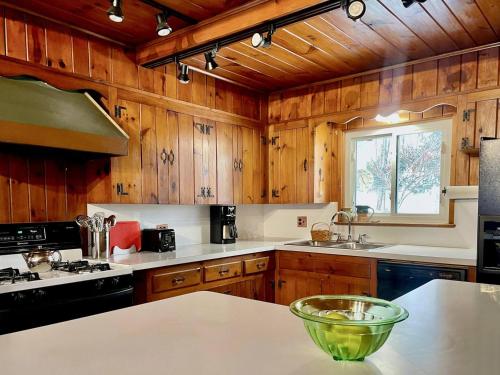 a kitchen with wooden cabinets and a counter top at Twin Oaks Near Lake Wallenpaupack Historic Home in Hawley