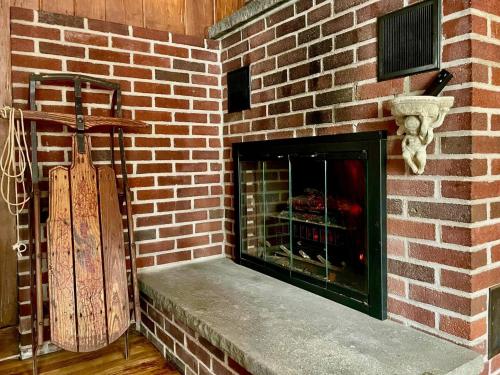 a brick wall with a fireplace in a room at Twin Oaks Near Lake Wallenpaupack Historic Home in Hawley