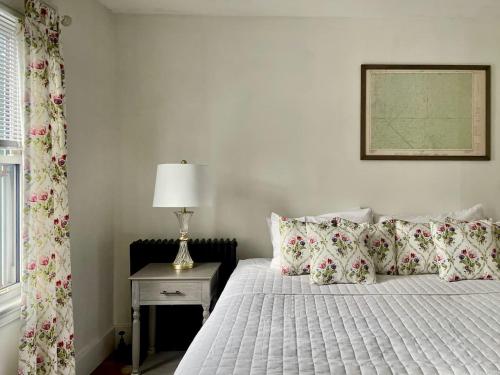 a bedroom with a bed and a table with a lamp at Twin Oaks Near Lake Wallenpaupack Historic Home in Hawley