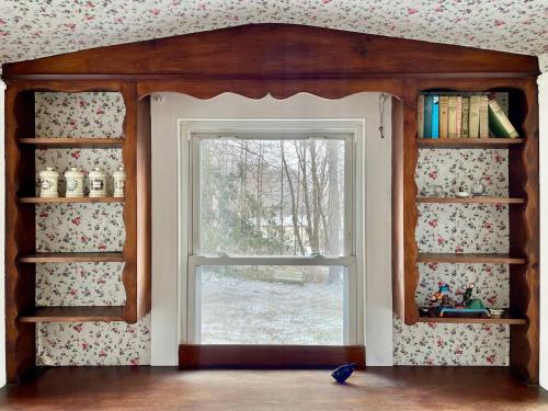 a room with a window and bookshelves at Twin Oaks Near Lake Wallenpaupack Historic Home in Hawley