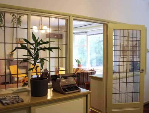 a room with a desk with a phone and a plant at Bie Beno in Groningen