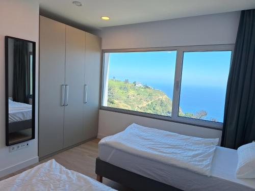Un dormitorio con una cama y una ventana grande. en Quinta do Munot, en Raposeira do Logarinho