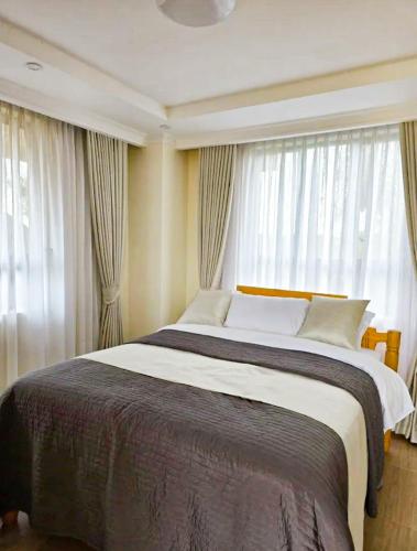 a bedroom with a large bed in front of a window at The Lantern Gardens - Oloirien in Kiserian