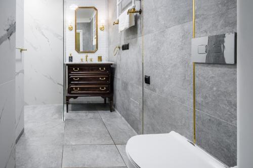 a bathroom with a sink and a toilet and a mirror at Househost Apt: Starowiślna 75/3/1 in Krakow
