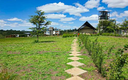 a stepping stone path in a field with a building at The Lantern Gardens - Oloirien in Kiserian