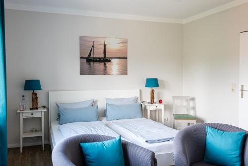 a bedroom with a bed with a sailboat on it at Hotel & Ferienunterkünfte Hus Seeblick in Fehmarn