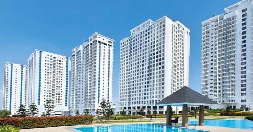 eine Gruppe hoher Gebäude mit einem Pool und einem Pavillon in der Unterkunft 2BR Penthouse SMDC Wind Residences Tagaytay in Kaybagal