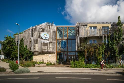 a person riding a bike in front of a building at ATHOME RESIDENCE ET SPA in La Rochelle