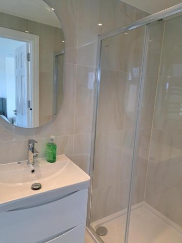 a bathroom with a shower and a sink and a mirror at Dominic's Home in Seven Kings