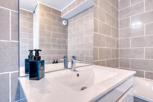 a bathroom with a white sink and a shower at L'instant Zen - CNPE Bugey - Centre Meximieux in Meximieux