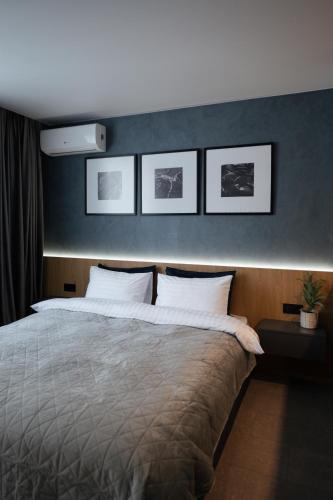 a bedroom with a large bed with three pictures on the wall at Апартаменти MYFREEDOM поруч із метро Васильківська in Kyiv