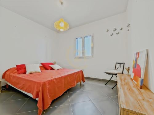 a bedroom with a bed with an orange blanket at La Parenthèse Corse in LʼÎle-Rousse