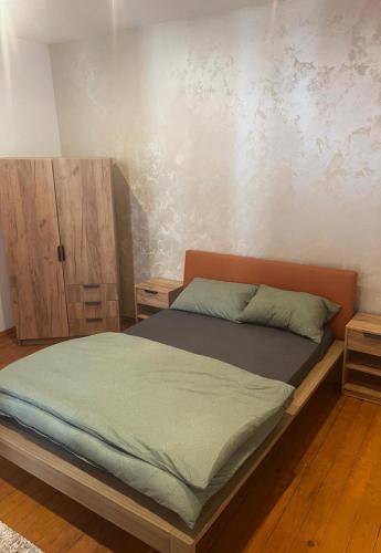a bedroom with a bed and a wooden cabinet at R&M old town sibiu in Sibiu