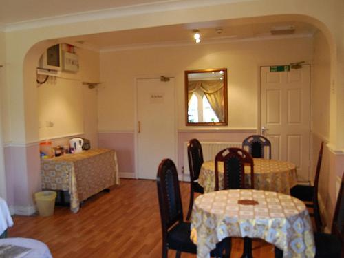 un comedor con 2 mesas y un espejo en Hillingdon Lodge, en Hillingdon