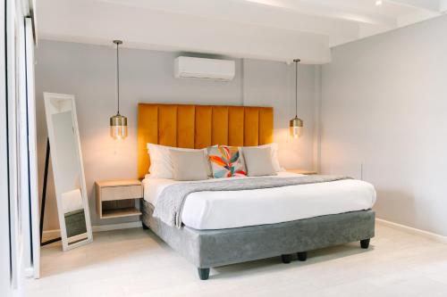 a bedroom with a large bed with a wooden headboard at The Salene Hotel & Apartments in Stellenbosch