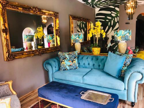 a living room with a blue couch and mirrors at Grafiti Boutique Hotel in Bela-Bela