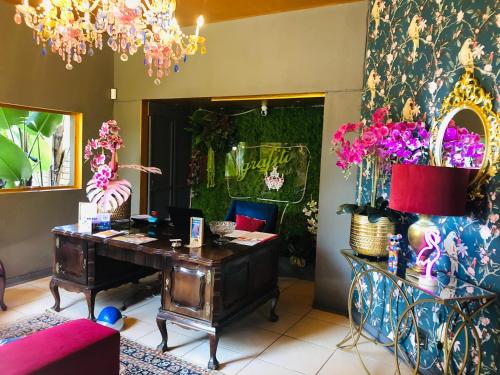 an office with a desk and flowers on the wall at Grafiti Boutique Hotel in Bela-Bela