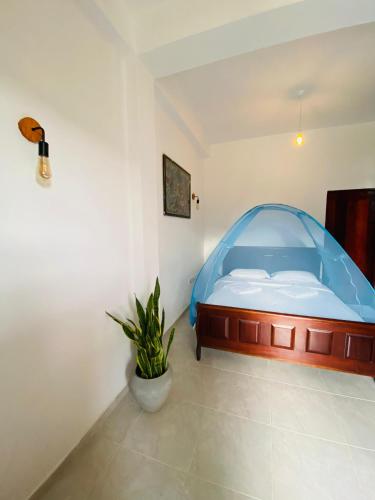 a bedroom with a bed with a blue canopy at Sudumal Cottage in Ella