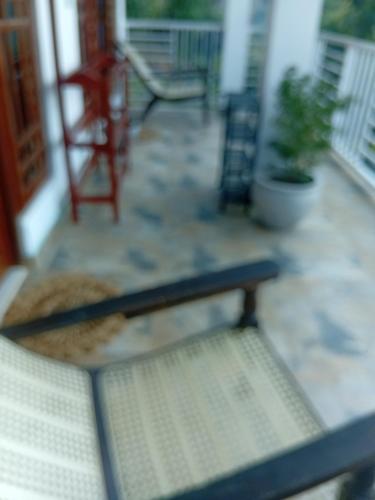 a bench on the porch of a house at Sudumal Cottage in Ella
