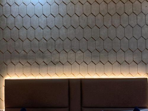 a tiled wall with a counter top with a laptop at Hotel NYASHA Ox Suites Near Delhi Airport in New Delhi