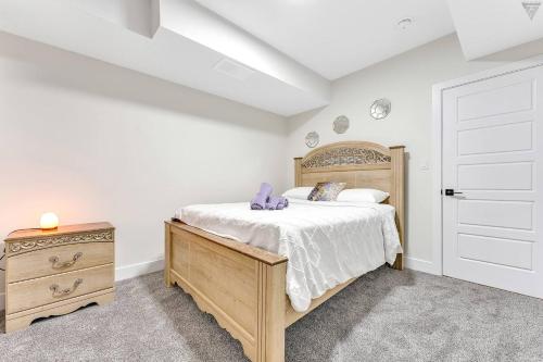 a bedroom with a bed and a dresser and a door at New Builtspacious Suite Bsmtgamesnetflix in Edmonton