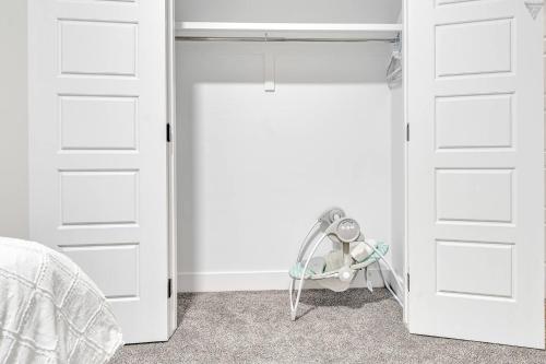 a bedroom with two white doors and a fan at New Builtspacious Suite Bsmtgamesnetflix in Edmonton