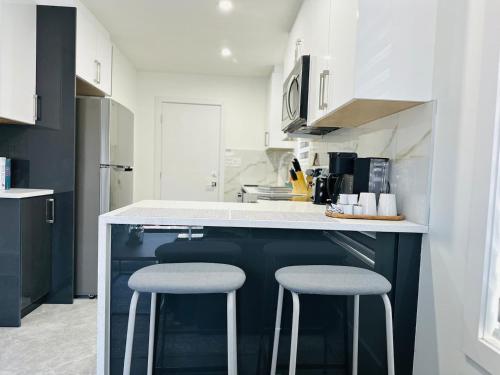 een keuken met twee krukken aan een aanrecht bij Cozy 2 bedroom suite Pet Friendly Heated Garage in Edmonton