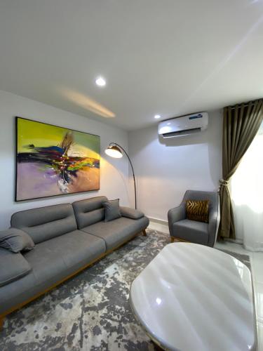 a living room with a couch and a large painting on the wall at Abuja City Tourist's Home in Abuja