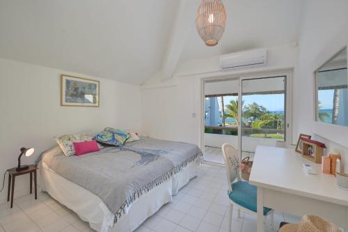 a bedroom with a bed and a desk and a table at Villa Océana, 2 bedrooms, sea view and beach access in Cap Malheureux