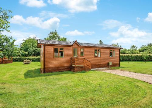 a small wooden cabin in a field of grass at Beaconsfield Park in Shrewsbury