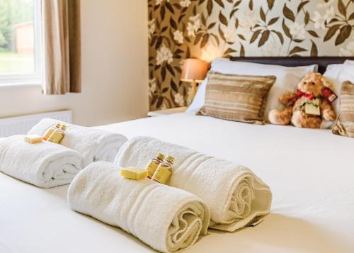a group of towels on a bed with a teddy bear at Beaconsfield Park in Shrewsbury