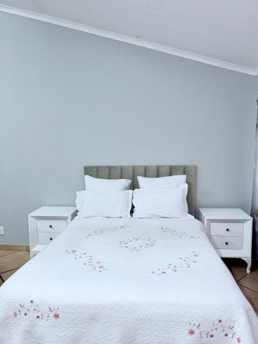 a bedroom with a white bed with flowers on it at Country Farm House in Delmas