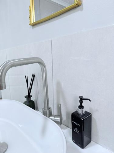 a bathroom sink with a black soap dispenser next to it at Country Farm House in Delmas