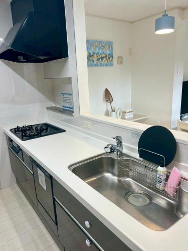 a kitchen with a sink and a stove at 美ら海水族館まで車で5分 ジャングリアにも車で25分の好立地 Villa Clownfish Reef in Motobu