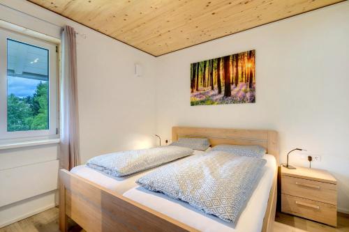 a bedroom with a bed and a painting on the wall at Ferienhäuser Stickel in Freudenstadt