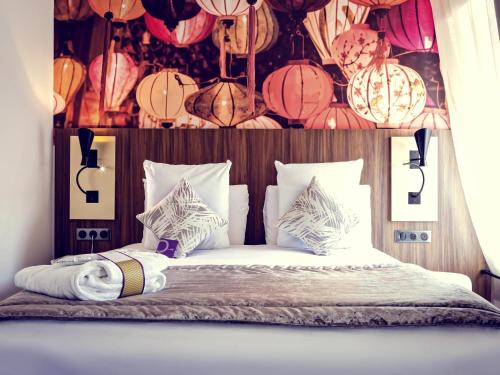 a bedroom with a bed with paper lanterns and lamps at Mercure Lyon Centre Plaza République in Lyon