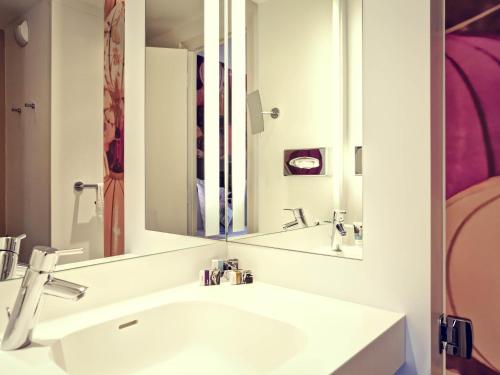 a bathroom with a sink and a mirror at Mercure Lyon Centre Plaza République in Lyon