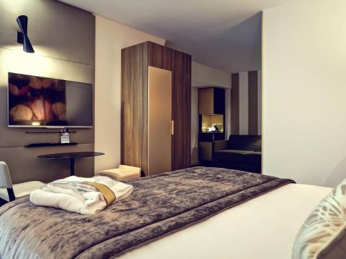 a hotel room with a bed with towels on it at Mercure Lyon Centre Plaza République in Lyon