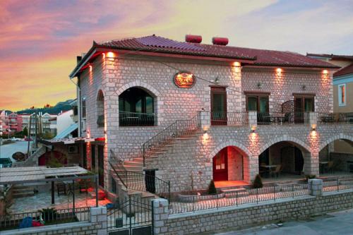 a brick building with a red door and stairs at Myral Guesthouse in Nafplio