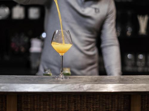 a drink is being poured into a wine glass at Mercure Grenoble Meylan in Meylan