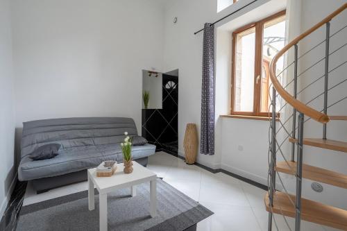 a living room with a bed and a table at L'Escale Pondi - A deux pas du château in Pontivy