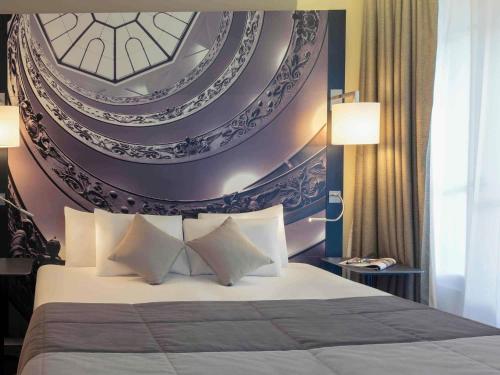 a bedroom with a large bed with a painting on the wall at Mercure Lyon Centre Beaux-Arts in Lyon