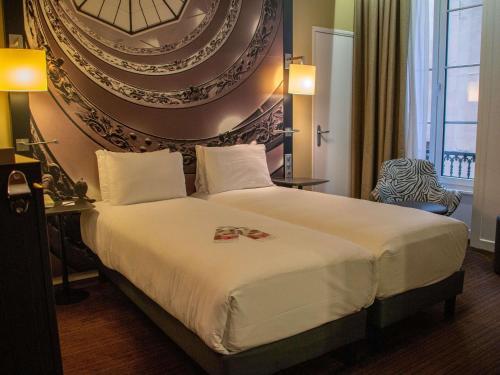 a hotel room with a bed and a large wall at Mercure Lyon Centre Beaux-Arts in Lyon