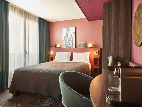 a hotel room with a bed and a chair at Mercure Paris Tour Eiffel Pont Mirabeau in Paris