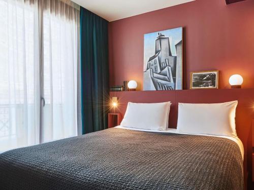 a bedroom with a large bed with red walls at Mercure Paris Tour Eiffel Pont Mirabeau in Paris
