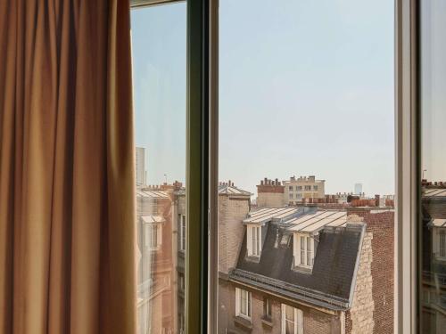 a window with a view of a building at Mercure Paris Tour Eiffel Pont Mirabeau in Paris