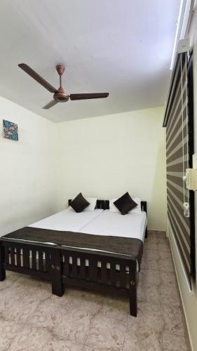 a bedroom with a bed with a ceiling fan at UPPERCREST RESIDENCY PALA in Pala