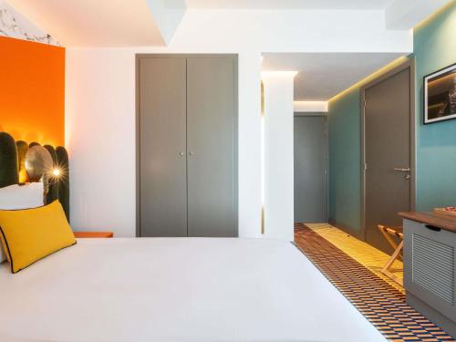 a bedroom with a white bed and colorful walls at Mercure Shéhérazade Rabat in Rabat