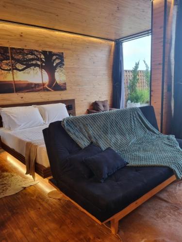 a bedroom with a bed and a couch at Parador dos Canyons in Cambará